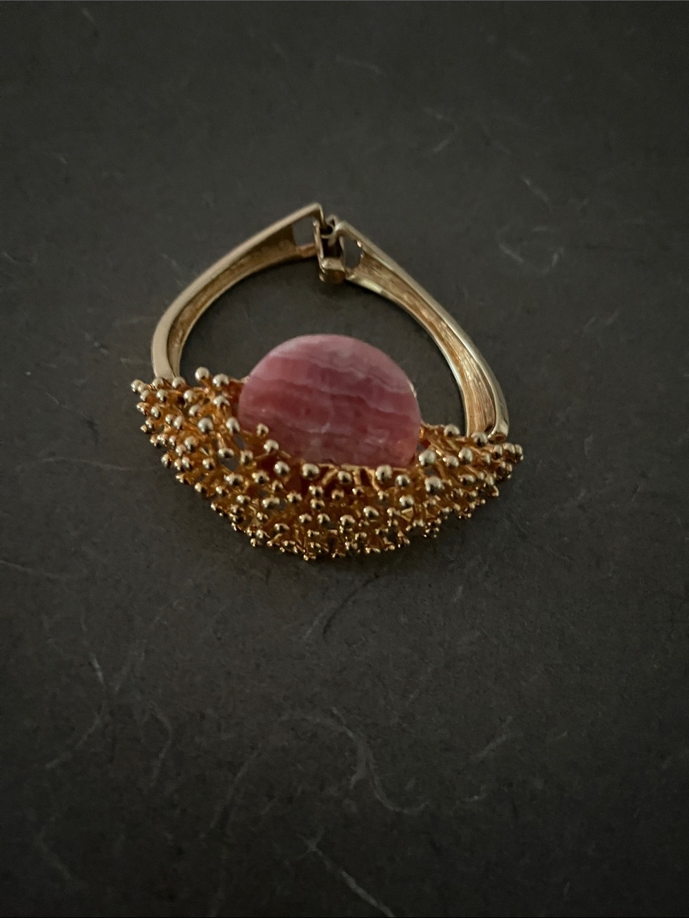 Gold-Tone Bracelet with pink accent.